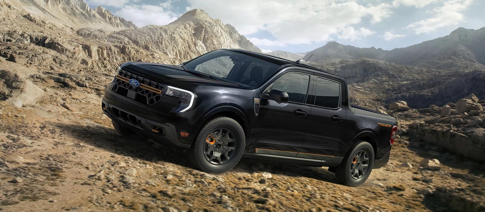 A black 2026 Ford Maverick pickup truck driving up a rocky mountainside